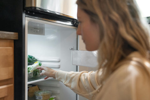 Woman reaching into the refrigerator
