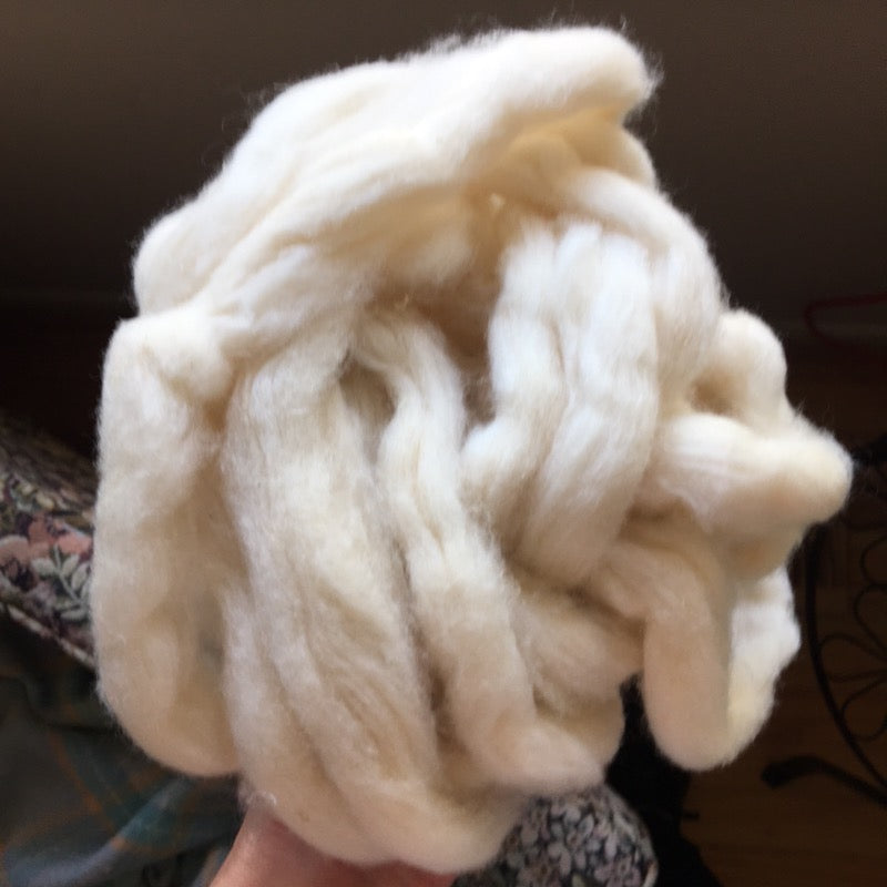 A ball of fluffy off-white fiber roving made from hemp and cotton