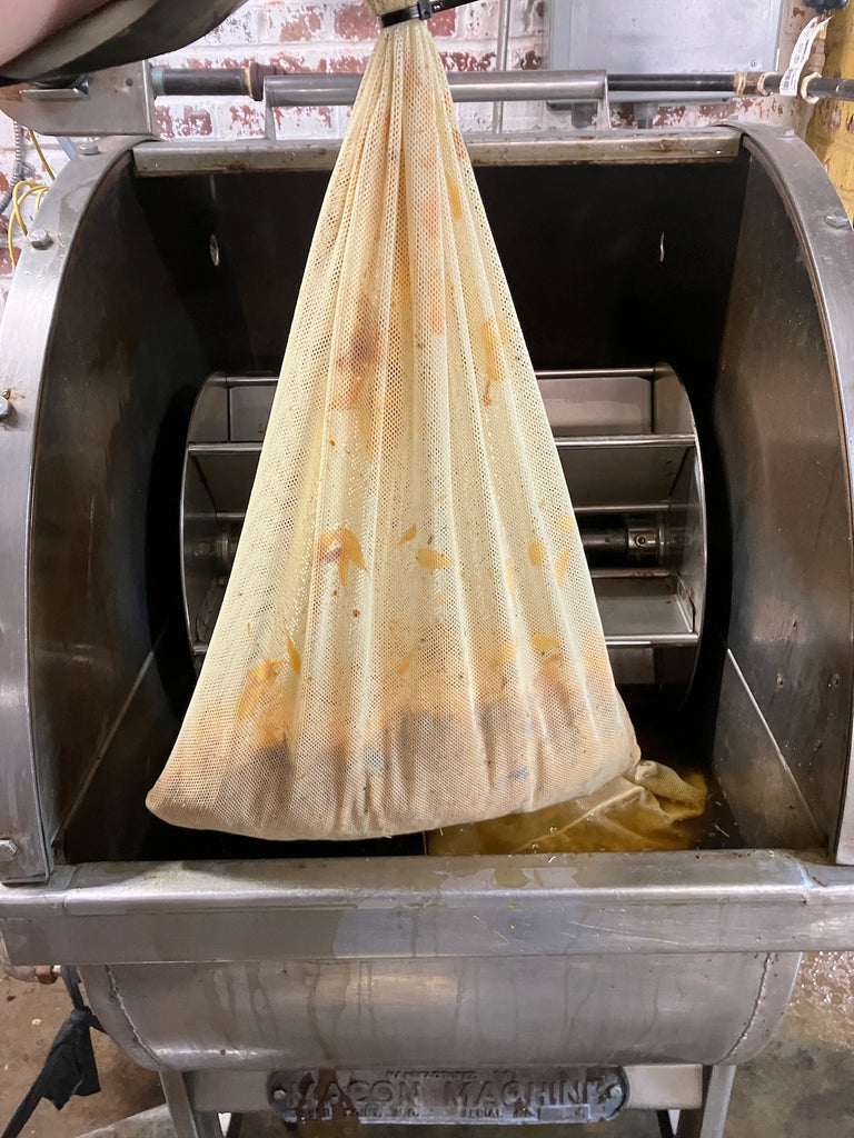 A mesh bag filled with marigolds about to go into the dye tub