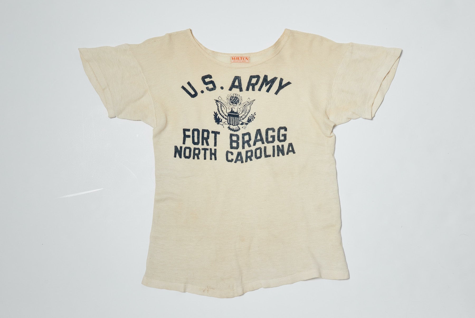A vintage white t-shirt with U.S. Army Fort Bragg North Carolina logo printed on the front
