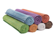 Rolled up organic cotton yoga mats stacked on top of each other.