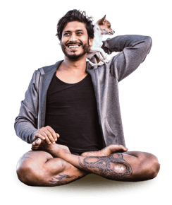 yoga teacher Jai Sugrim sitting in a cross-legged position with a small dog on his shoulder