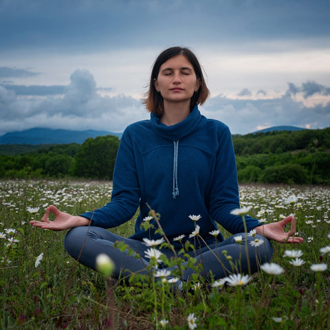 yogi meditating in a field of grass