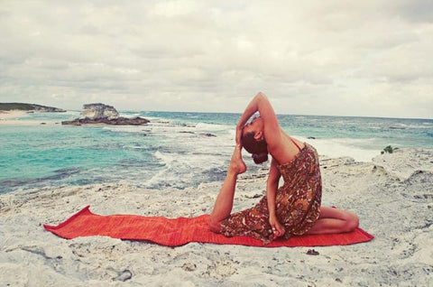 Yogi practicing backbend by the ocean on an organic cotton yoga mat