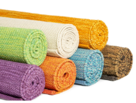 Rolled up cotton yoga mats stacked together