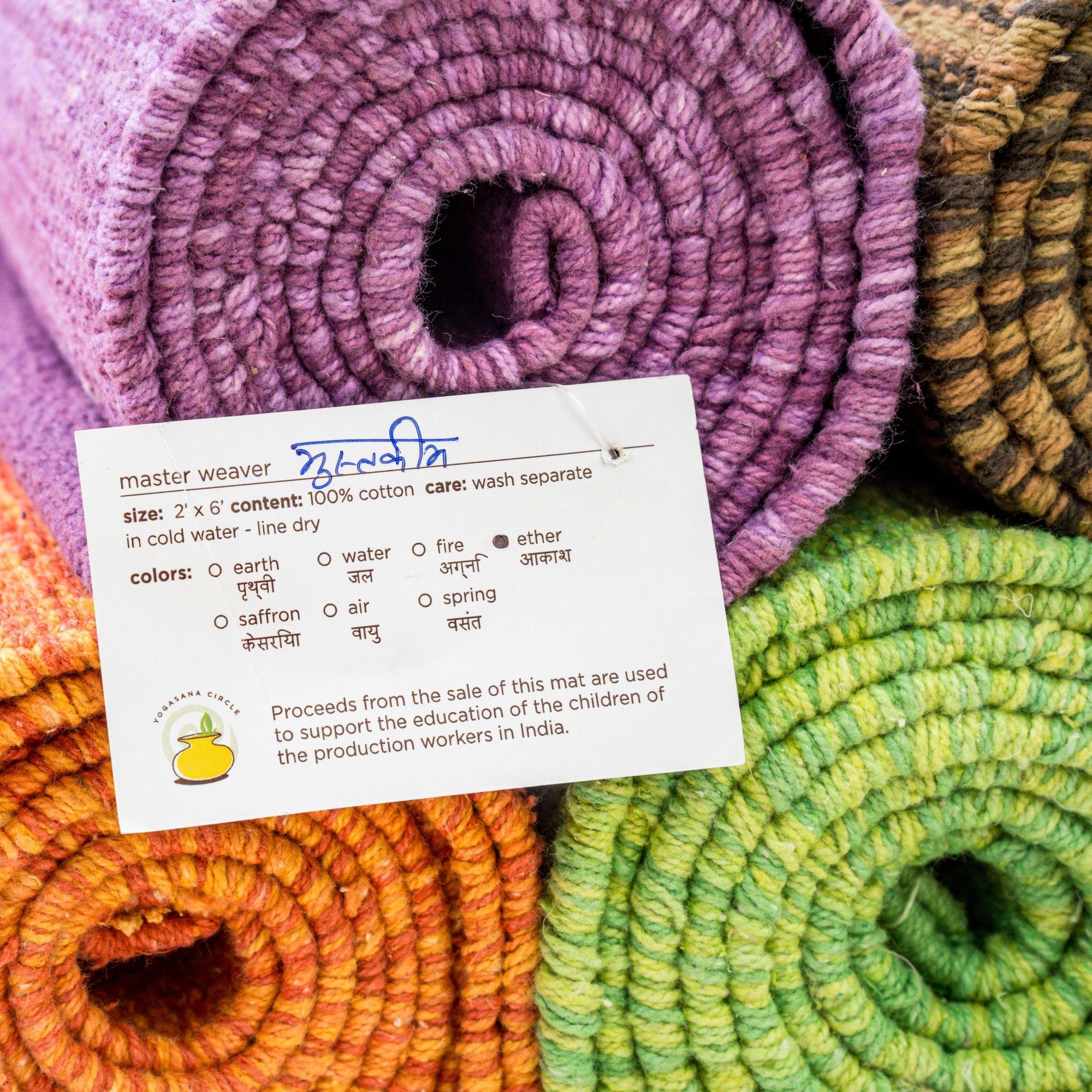 Rolled up organic cotton yoga mats with the weaver's signature card