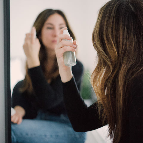 beauty routine, hair oil, hair spray, woman in front of mirror