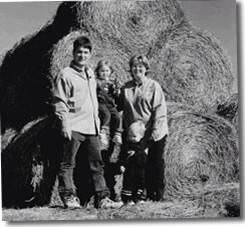 Greg, Lei, Kara, & Evan Gunthorp in 1998 standing on straw bales.