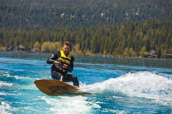 Wake surfing in Lake Tahoe on a wooden surf board