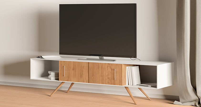 A white and wood grain entertainment unit with two closed cabinets in the centre and two open shelves on either side. The shelves are holding stacks of books and there is one open magazine on top. The unit is holding a large plasma TV, off.