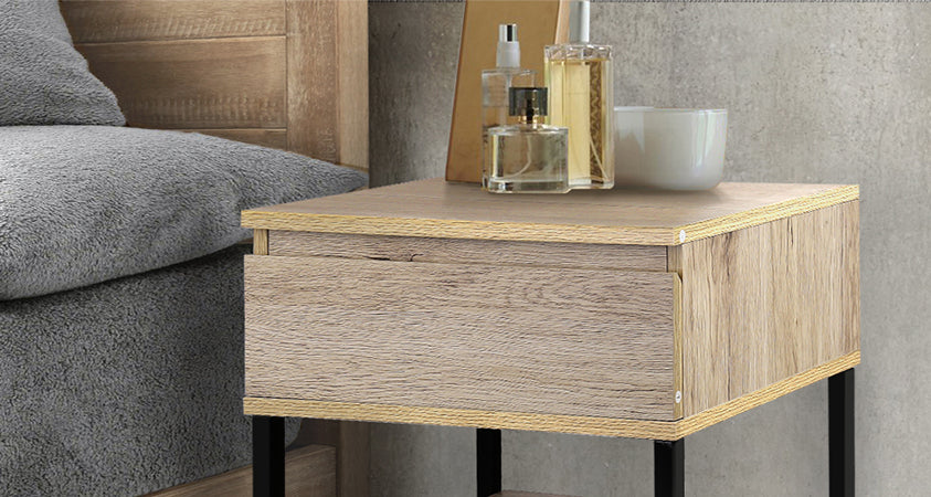 A close-up of the Artiss Casey bedside table fitted with a recessed finger-pull handle is a beautiful combination of wood and metal that provides ample space with its wide surface, single drawer, and bottom shelf. 