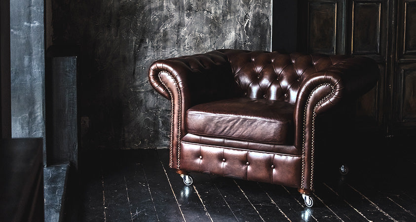 This classic dark brown leather chesterfield armchair with castor wheels transforms this dramatic rustic-style room into a rich, soulful place you would never want to leave.  