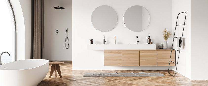 A typical two person bathroom vanity with a wood grain base, white countertop and two circular mirrors.