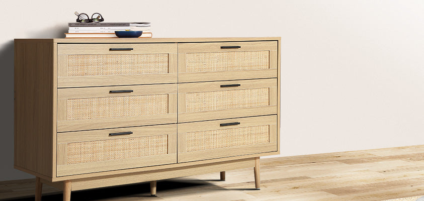 An Artiss 6-drawer rattan chest of drawers set in a plain room with white walls and a light wood floor.