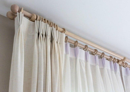 white linen sheer curtain on a brass rod