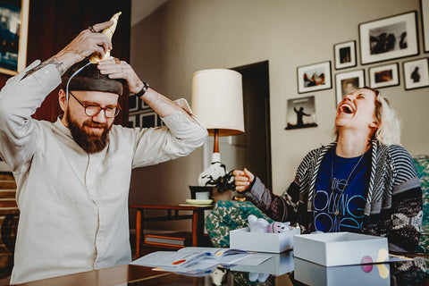 couple using date night box on couch and laughing