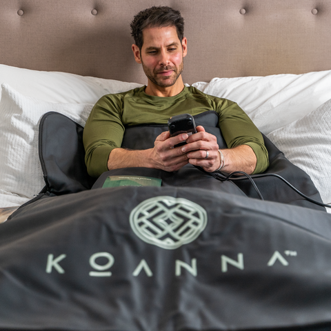 Man relaxing in his black Koanna Infrared Sauna Blanket