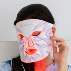 Women wearing a red light therapy mask