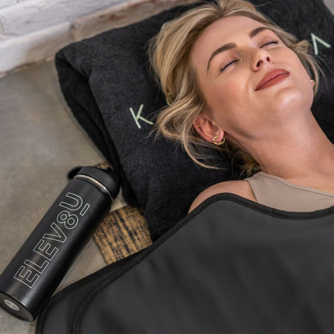 Woman relaxing in her black Koanna Infrared Sauna Blanket