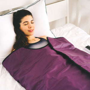 woman using the purple infrared sauna blanket