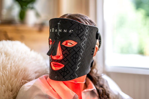 Woman using the red light of the Koanna LED Mask