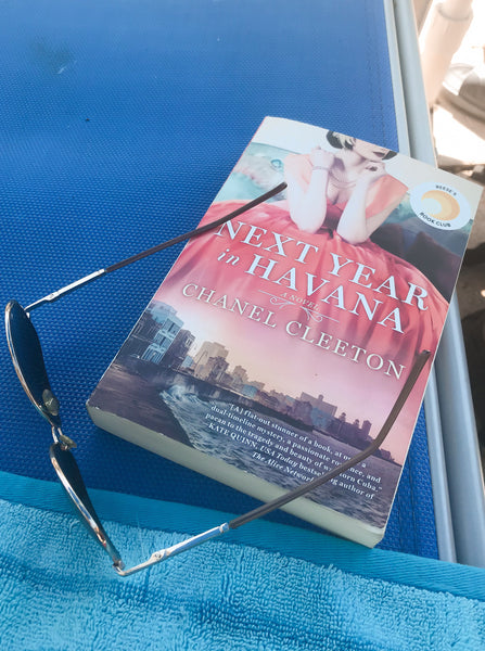 Sanderling Life- Next Year In Havana Book with aviator sunglasses on blue beach chair