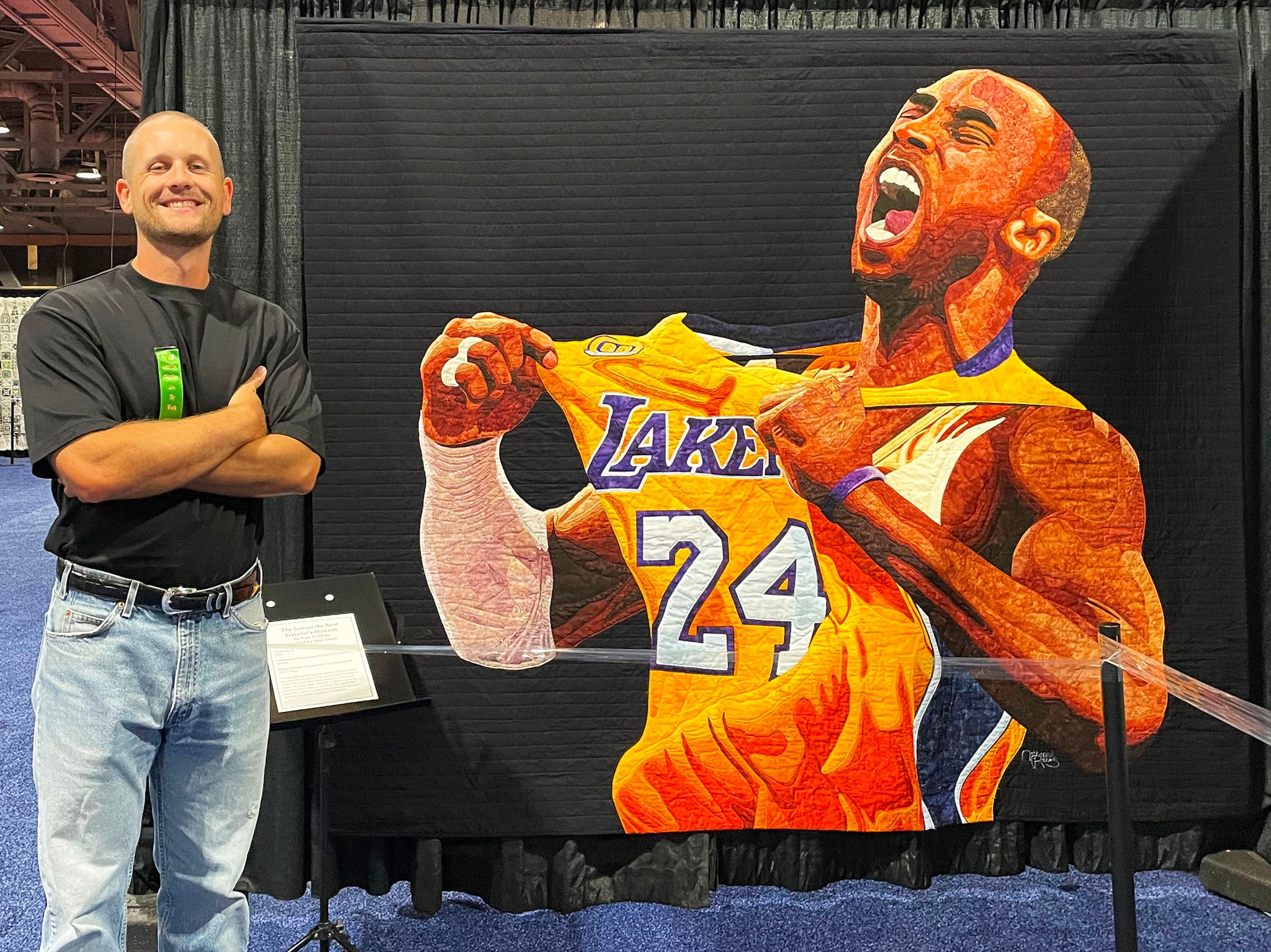 Long Beach Quilt Festival 2023 - Nate Robbins in front of his quilt The Sun on the Next Traveler’s Horizon, quilted by Nan Akins - Photo By Victoria Stone