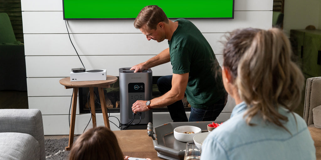 A man plugs an entertainment system into the HomePower 2 power station.