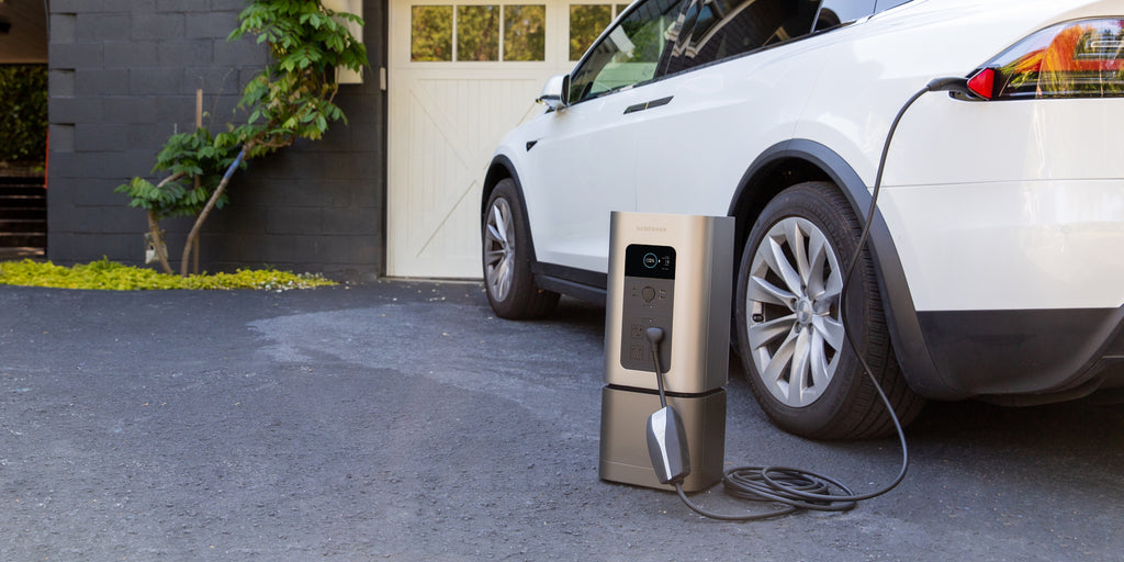 The HomePower 2 sits in a driveway charging from a carport.