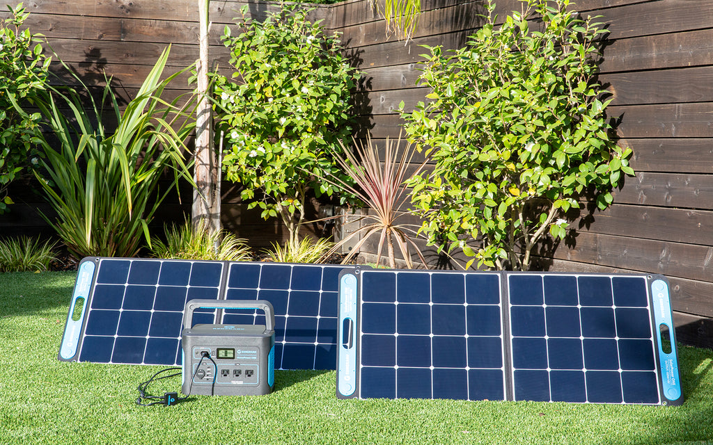 The HomePower ONE backup battery generator and SolarPower ONE solar panel power station are pictured on an outdoor lawn.