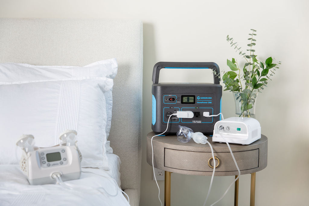 The HomePower ONE portable power station is pictured on a night stand, powering a CPAP machine and breast pump, which is sitting on the bed.