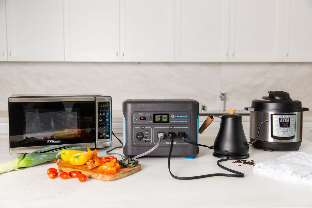 The HomePower portable power station is on a kitchen counter powering a microwave, kettle, and slow cooker.