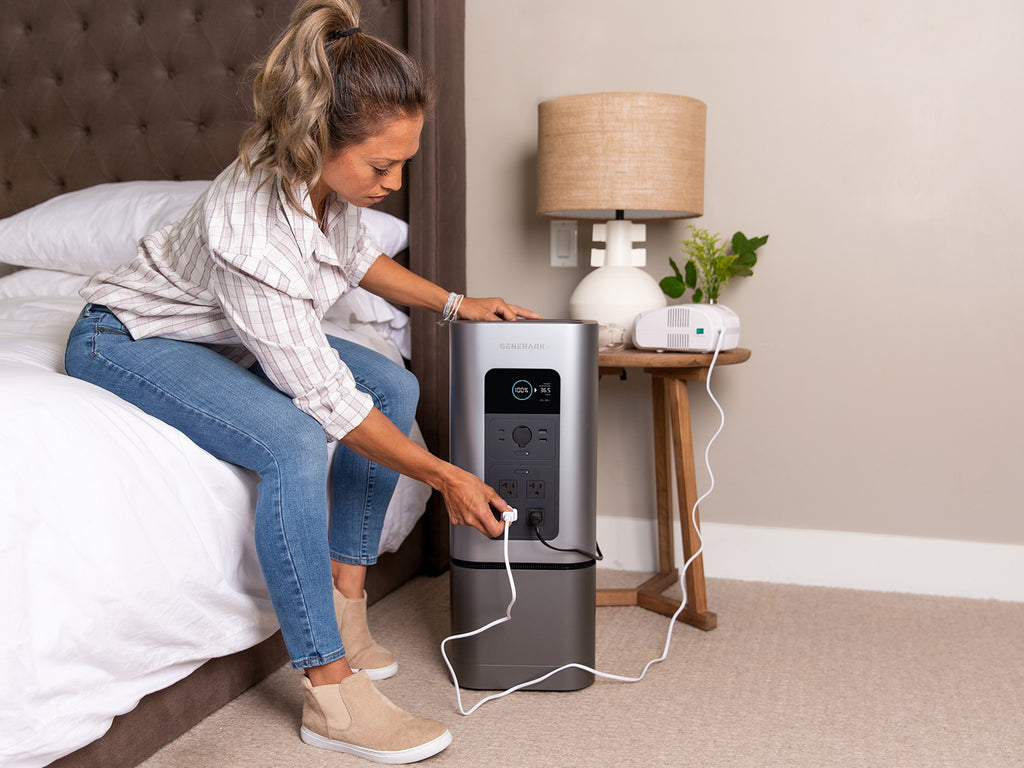 A woman plugs a medical device into the HomePower 2 in a bedroom.