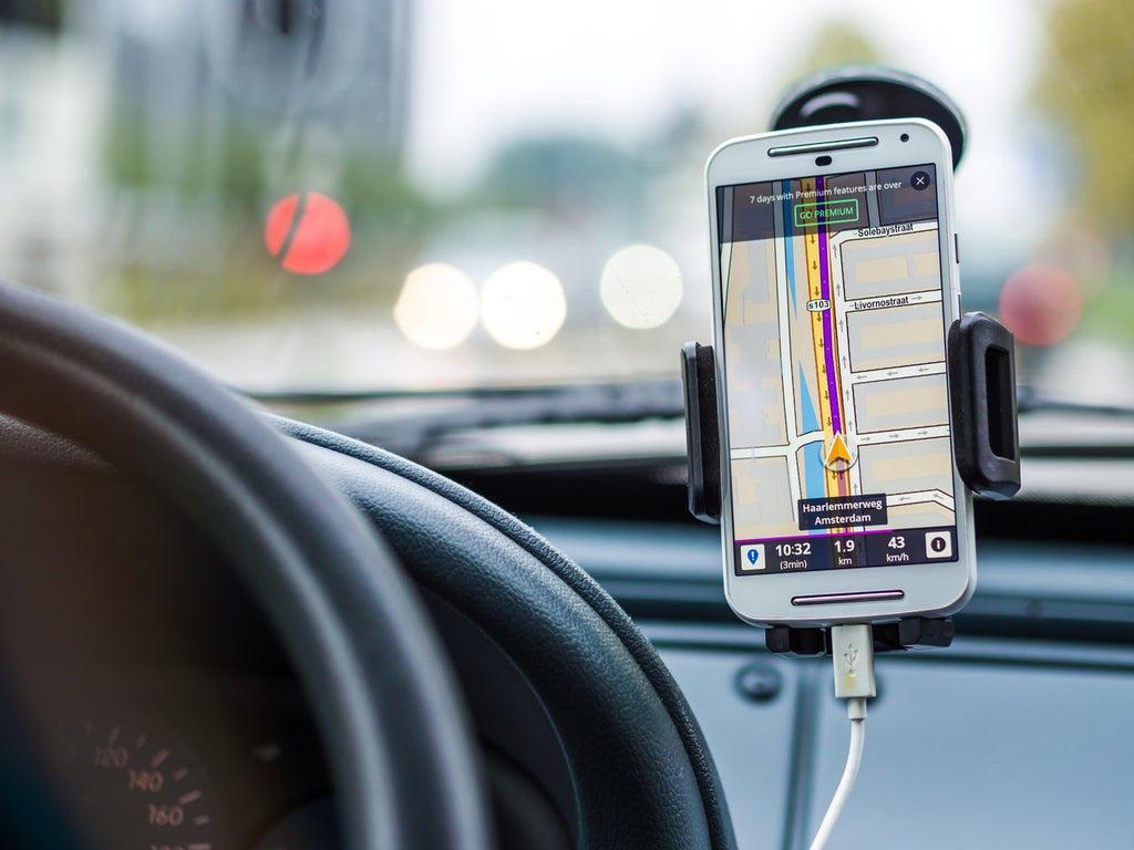 A cell phone is plugged into a car acting as a GPS.