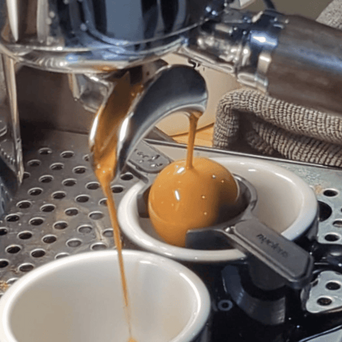 A photo of a shot of espresso being pulled onto a metal ball.