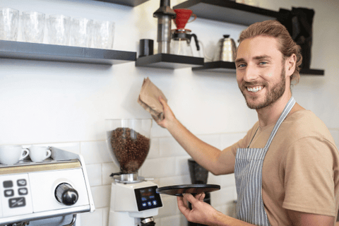 Photo of a man pouring coffee beans into his bean hopper.