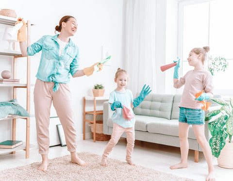 Mom and daughters dancing and cleaning in living room