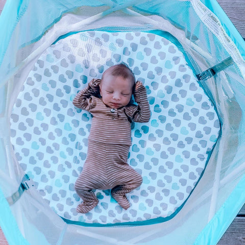 baby sleeping in portable bassinet