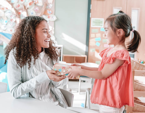 Student handing teacher a gift