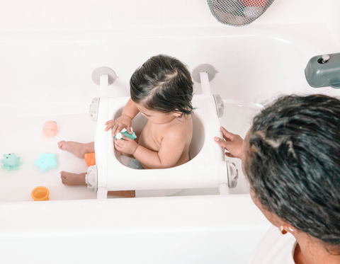 Baby Playing in the Bathtub while Sitting in the Baby Basics Bath Seat