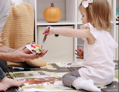 Toddler Dipping Paint Brush into Paint