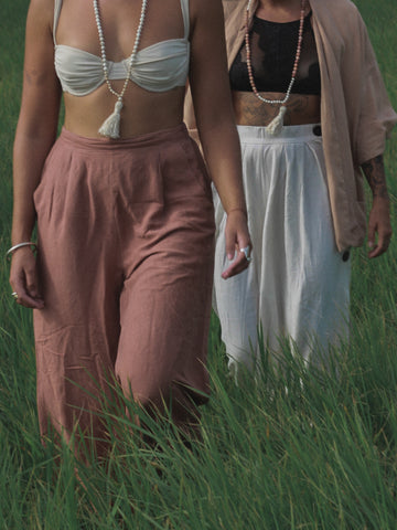 Two women walk through tall grass