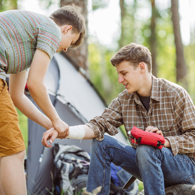 first aid kit while camping helping out a friend with his arm