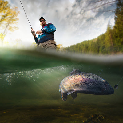 pulling in a fish while fishing at the lake