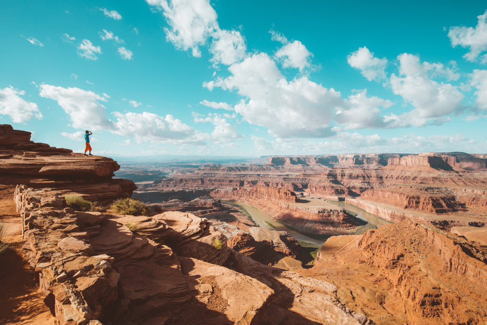 Hiker Standing on Cliff Edge in Canyonlands National Park Utah