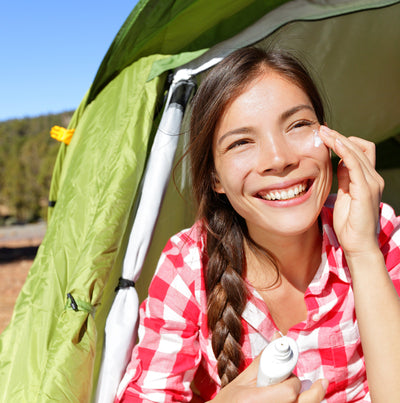 Girl lathering on sunscreen before her hike 