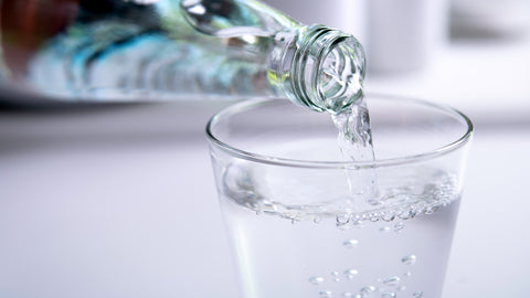 bottle of water being poured into a glass