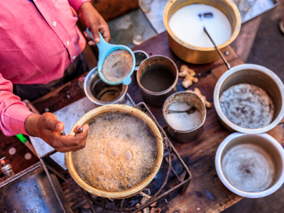 Hombre preparando Masala Chai indio/té negro especiado