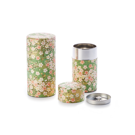 two tea canisters. One closed (light sage green decorated with blossoms in shades of pink and gold accents). Next to the same tin that is open to reveal a stainless rim and inside lid with knob.