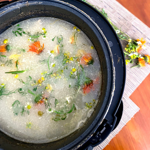 Pot of bone broth with chicken bones and herbs added